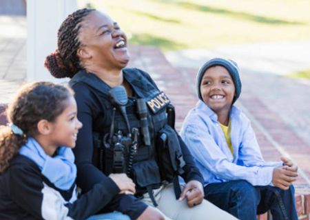 police officer sitting with two children laughing